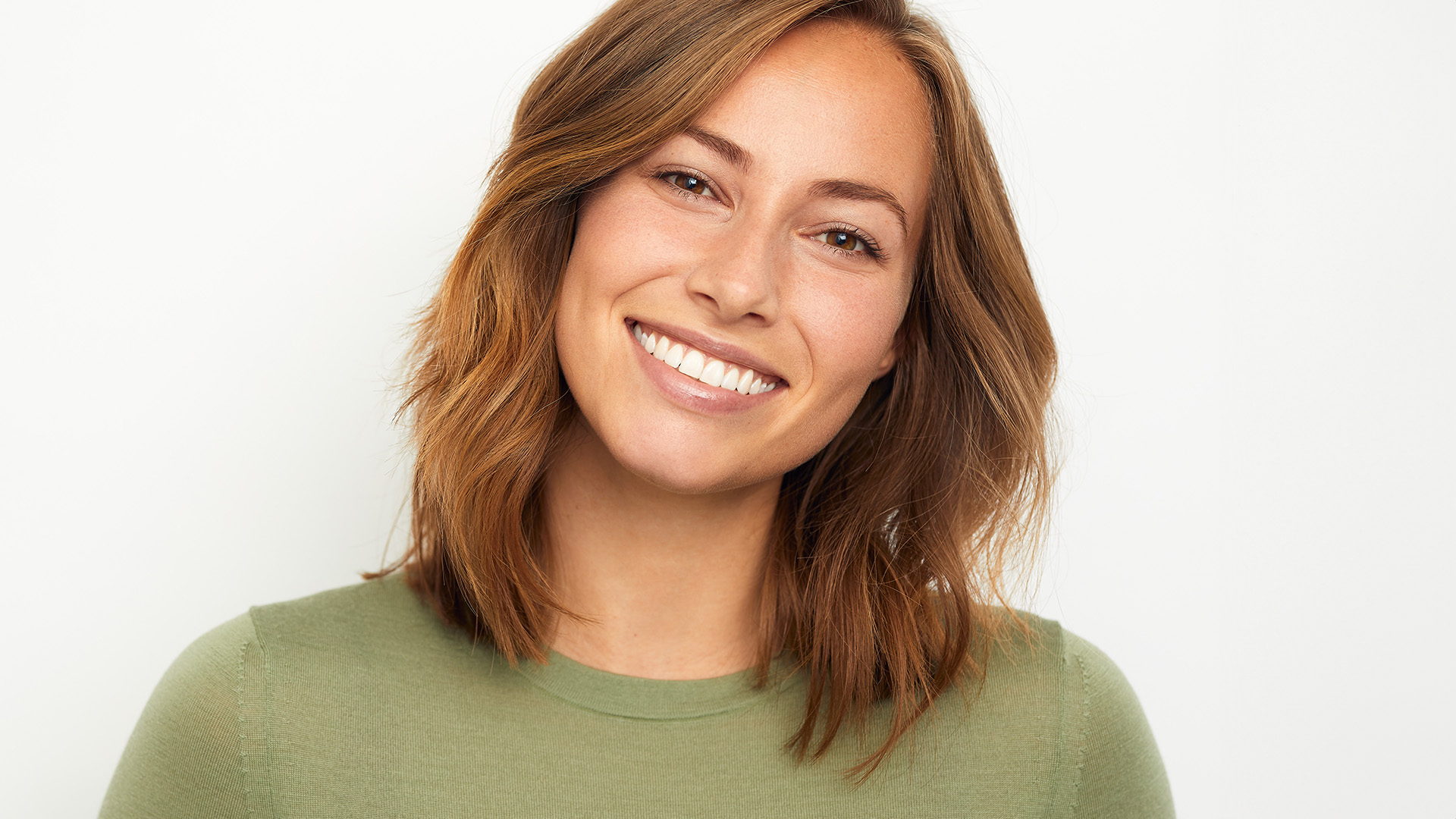 A woman with short hair smiles at the camera.