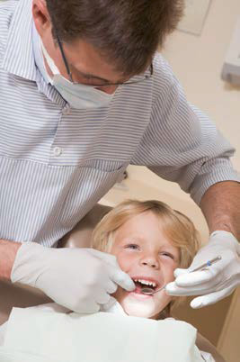 A dentist assisting a young boy with dental care.