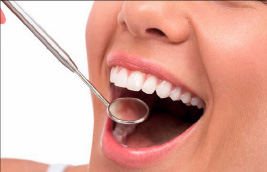 A person with open mouth showing teeth, receiving dental care with a spoon-like instrument in their mouth.